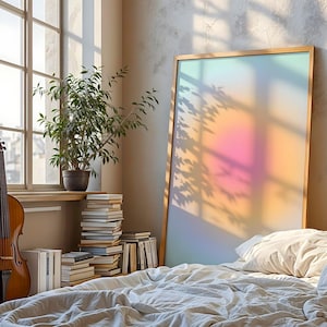 Puede incluir: Una escena de dormitorio con un violonchelo, libros y una gran obra de arte enmarcada. La obra de arte tiene un degradado de color suave. Una planta en maceta est&aacute; en un alf&eacute;izar. La cama est&aacute; hecha con un edred&oacute;n y almohadas blancos.