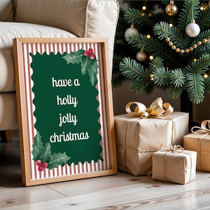Könnte beinhalten: Ein rechteckiger Holzrahmen mit einem Druck auf rot-weiß gestreiftem Hintergrund und einem dunkelgrünen, gewellten Mittelteil. Der Text "have a holly jolly christmas" ist in Weiß gedruckt, akzentuiert durch grüne Stechpalmenblätter und rote Beeren.