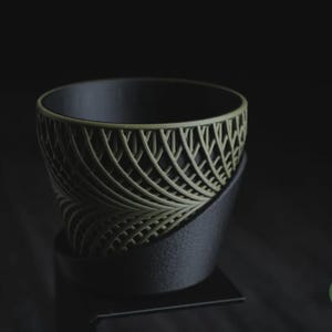 Peut inclure: Un bol décoratif noir et vert olive avec un design ajouré unique. Le bol repose sur une base noire et l'intérieur est noir uni. Le design rappelle des feuilles.
