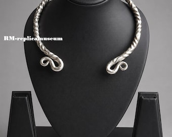 May include: A silver-colored necklace with a twisted rope design, displayed on a black jewelry bust. The necklace has curled ends. The bust is on a gray background. The text "RM-replica museum" is visible on the left side.