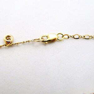 May include: A gold chain necklace with a lobster clasp closure. The chain is made of small, linked circles.