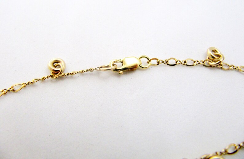 May include: A gold chain necklace with a lobster clasp closure. The chain is made of small, linked circles.
