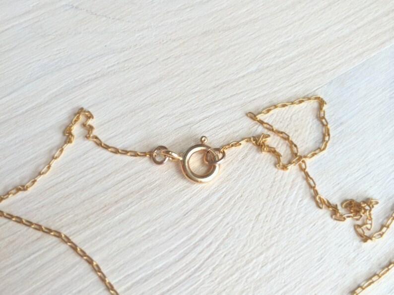 May include: A gold chain necklace with a lobster clasp closure.