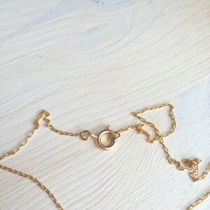 May include: A gold chain necklace with a lobster clasp closure.