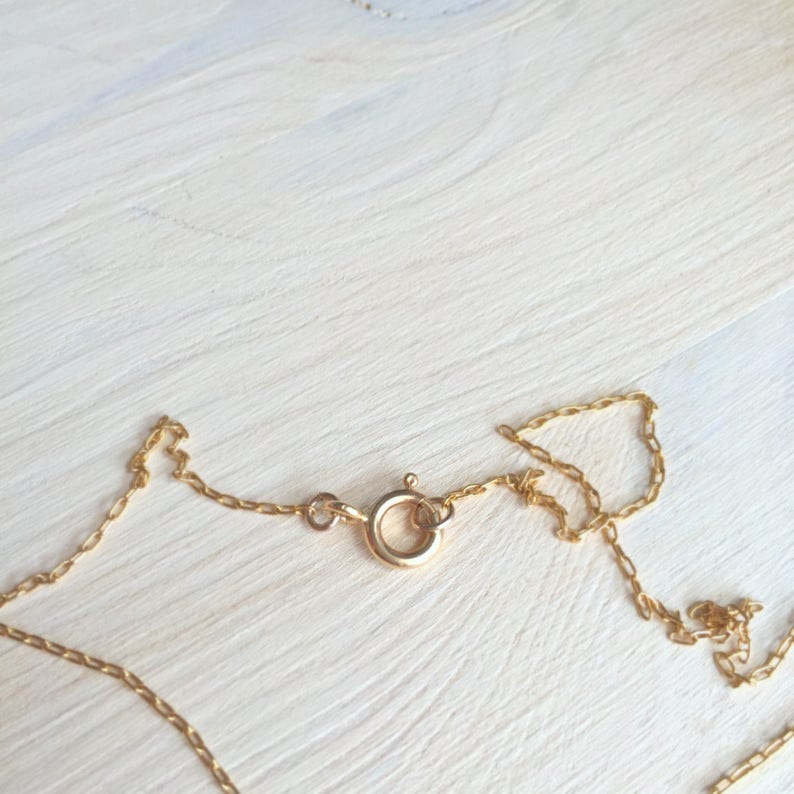 May include: A gold chain necklace with a lobster clasp closure.