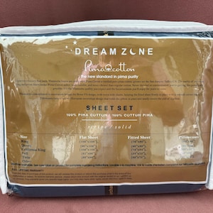 May include: A packaged sheet set with the Dream Zone and Pima Cotton labels. The packaging is clear, showing the sheet set inside. The text on the packaging includes "Sheet Set" and size information.