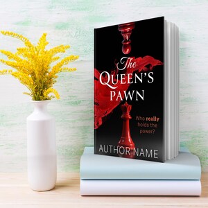 K&ouml;nnte beinhalten: Ein Buch mit dem Titel "The Queen's Pawn" mit einem roten Schachfigurendesign auf schwarzem Hintergrund, gestapelt auf zwei weiteren B&uuml;chern. Links steht eine wei&szlig;e Vase mit gelben Blumen.