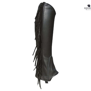 May include: Black leather riding chaps with fringe detail along the outer side. These chaps are designed to protect the rider's legs and are suitable for equestrian activities. The chaps are shown against a white background.