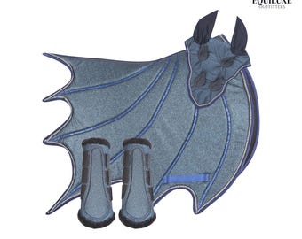 May include: A blue and black horse riding set, including a saddle pad with wing-like design, ear bonnet, and two matching leg wraps. The set has blue accents and is designed to resemble a dragon.