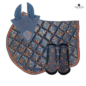 Puede incluir: Un conjunto ecuestre con temática de Halloween que incluye una manta de silla acolchada, una gorra para las orejas y dos vendas para las piernas. El conjunto es de color gris oscuro con caras de calabaza naranja y ribetes naranjas. La gorra y las vendas tienen un diseño a juego.