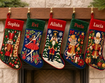 Puede incluir: Cinco calcetines navideños de punto de aguja colgados de una repisa de madera. Cada calcetín presenta un diseño festivo único con un cascanueces, una bailarina y ratones, con los nombres Sophia, Evi, Alisha, Perla y Lucia bordados.