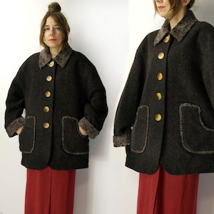 Könnte beinhalten: Ein dunkelbrauner Wollmantel mit strukturiertem Muster. Der Mantel hat einen Kunstfellkragen und -manschetten, große Taschen und goldfarbene Knöpfe. Der Mantel ist knielang und hat einen klassischen Vintage-Stil.