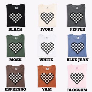 Pu&ograve; includere: Nove magliette di diversi colori, ognuna con una grafica a cuore a scacchi usurata. I colori includono nero, avorio, pepe, muschio, bianco, blu jeans, espresso, igname e fiore. La parola per ogni colore &egrave; stampata sotto la maglietta.
