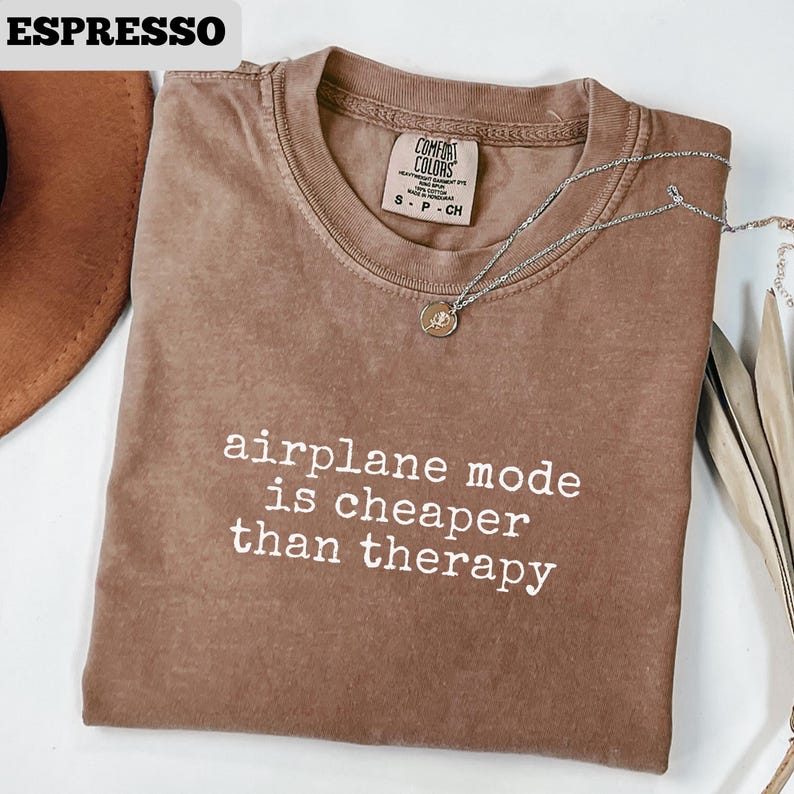 May include: A white ceramic mug with a black handle and the text "But First, Coffee" in a black, bold font. The mug is on a white surface. The mug is 4 inches tall.