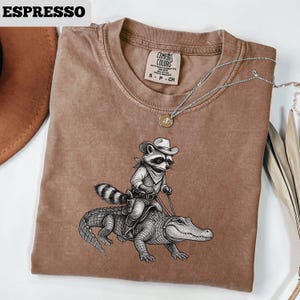 Vintage Cowboy Raccoon Riding Alligator T-Shirt, Western Animal Lover Tee, Vintage Wildlife Adventure Shirt, Funny Cartoon Ranch Tee image 1