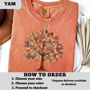 May include: A coral-colored t-shirt featuring a detailed tree design with a patchwork-style canopy. The shirt has a crew neck and short sleeves. A gold necklace with a pendant rests on the shirt. The text "HOW TO ORDER" is visible at the bottom.