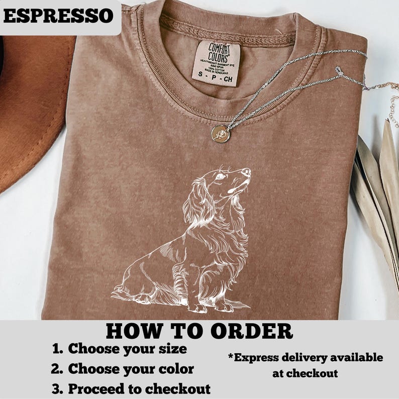 May include: Espresso-colored t-shirt featuring a white illustration of a long-haired dachshund. The shirt has a crew neck and short sleeves. The text "COMFORT COLORS" is visible on the tag. The words "HOW TO ORDER" and instructions are printed at the bottom.