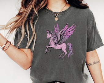Pink violet winged unicorn T-shirt, fantasy pegasus creature with purple mane, majestic horned horse in flight, magical pastel equine tee