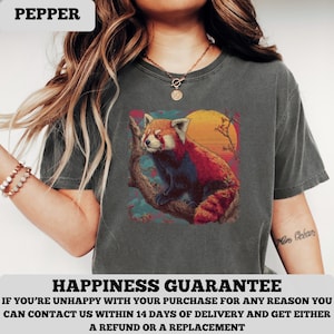 Puede incluir: Camiseta gris oscuro con una ilustraci&oacute;n de un panda rojo en una rama contra un atardecer. La palabra "PEPPER" est&aacute; en la parte superior. La camiseta tambi&eacute;n tiene el texto "HAPPINESS GUARANTEE" en la parte inferior.