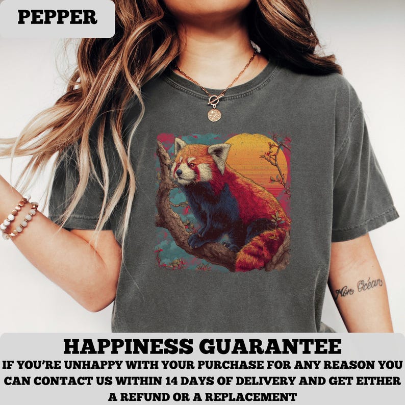 Puede incluir: Camiseta gris oscuro con una ilustraci&oacute;n de un panda rojo en una rama contra un atardecer. La palabra "PEPPER" est&aacute; en la parte superior. La camiseta tambi&eacute;n tiene el texto "HAPPINESS GUARANTEE" en la parte inferior.