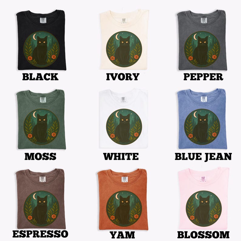 May include: Nine different colored t-shirts are displayed, each with a graphic of a black cat inside a circle with a moon and flowers. The shirt colors include black, ivory, pepper, moss, white, blue jean, espresso, yam, and blossom.