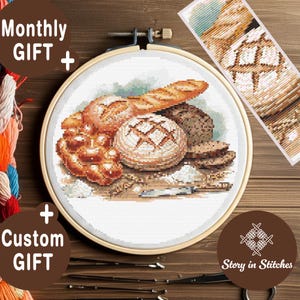 Puede incluir: Un bastidor de bordado de punto de cruz con una imagen detallada de varios panes, incluyendo una baguette, hogazas redondas y panecillos. El texto "Monthly GIFT + Custom GIFT" es visible. El diseño está sobre un fondo de madera.