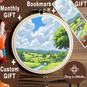 May include: A cross-stitch landscape scene featuring a blue sky with fluffy white clouds, green fields, and a river. The scene is framed in a wooden embroidery hoop, with a matching bookmark. Text on the image says "Monthly Gift", "Bookmark Gift", and "Custom Gift".