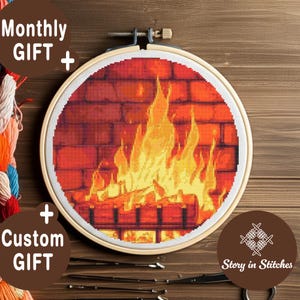 Puede incluir: Un bastidor de bordado de punto de cruz con una acogedora escena de chimenea. El diseño muestra una pared de ladrillos con llamas y troncos. También se ve el texto "Monthly GIFT + Custom GIFT" y "Story in Stitches".