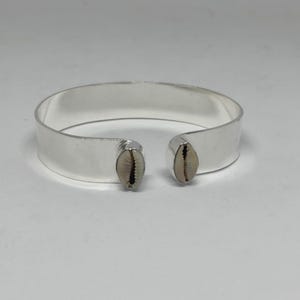 Pulsera tipo brazalete con conchas de cauri, brazalete abierto, joyería playera de estilo tribal bohemio chic.