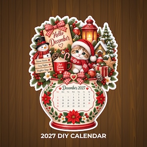 May include: A decorative December 2027 calendar sticker featuring a kitten in a Santa hat, a snowman, a red lantern, and a mug labeled Hot Cocoa Season. The design includes a sign saying Hello December, pine branches, and poinsettia floral motifs.