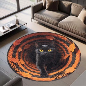 May include: A round rug featuring a black cat with yellow eyes, surrounded by orange and brown autumn leaves and spiderwebs. The rug has a quilted border and a dark center, creating a Halloween theme.