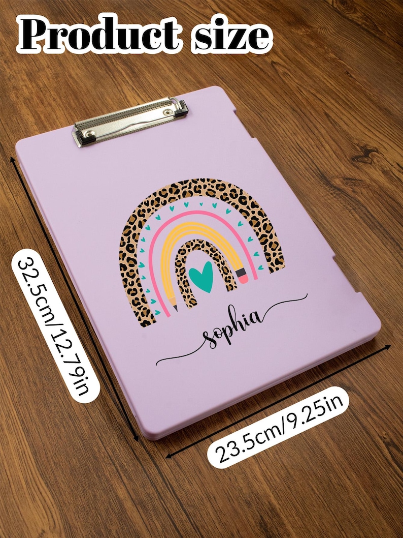 May include: A lavender clipboard with a rainbow design and the name "Sophia". The rainbow features a leopard print section, with pink, yellow, and blue arcs. The clipboard measures 12.79 inches by 9.25 inches.