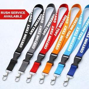 Pode incluir: Seis cordões em várias cores: preto, cinza, vermelho, laranja, azul claro e azul escuro. Cada um apresenta o texto branco "CUSTOM TEXT" e inclui um fecho de plástico preto e um gancho de metal prateado. A frase "RUSH SERVICE AVAILABLE" está em uma faixa vermelha.