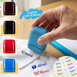 Può includere: Un timbro blu con nome personalizzato è tenuto sopra una superficie bianca con nomi e icone stampati. L'immagine mostra esempi di utilizzo del timbro, inclusi nomi come "Alfred" e "Bruce". Il testo "Custom Icon & Name" è anche visibile.