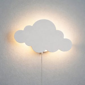May include: White cloud-shaped wall light fixture. The light has a soft, warm glow emanating from behind the cloud. A pull chain hangs below the fixture. The light is mounted on a textured, off-white wall.