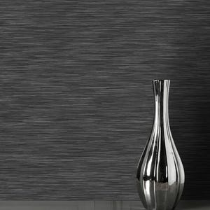 May include: A shiny silver vase with a narrow neck and a bulbous body. The vase is set against a dark grey wall with a textured, linear pattern. The design creates a modern and elegant look, suitable for home decor.