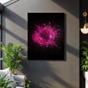 May include: A framed art print featuring a pink disco ball exploding against a black background. The image captures the moment of impact with shards and particles radiating outwards. The artwork is a vibrant and dynamic piece.