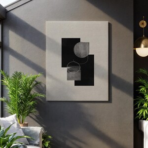May include: Abstract art canvas print featuring geometric shapes in black and gray on a neutral background. The design includes rectangles, circles, and textured elements, creating a modern aesthetic. The artwork is displayed on a wall in a well-lit room.