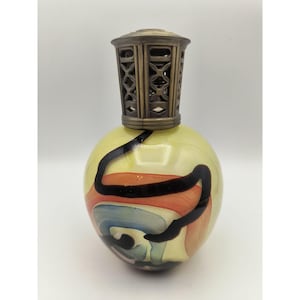 May include: A spherical glass fragrance lamp featuring a pale yellow base with swirling abstract patterns in black, orange, and blue. The top is finished with a decorative, perforated metallic cap in a muted bronze tone with a lattice design.