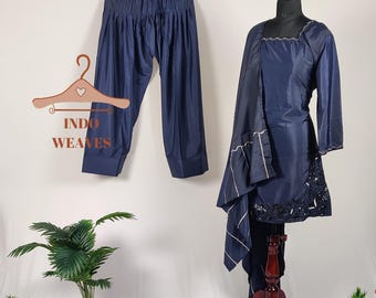 Könnte beinhalten: Marineblaues Salwar Kameez-Set. Das Set beinhaltet eine langärmlige Tunika mit weißer Bordüre und einen passenden Dupatta, der auf einer Schaufensterpuppe präsentiert wird. Eine passende Hose hängt an einem Holzbügel. Der Text "INDO WEAVES" befindet sich auf dem Bügel.