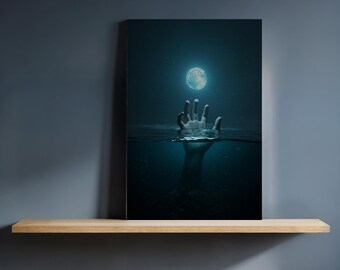May include: A canvas print depicting a surreal scene of a hand reaching towards a glowing full moon underwater. The artwork is set against a dark, blue-toned background, creating a dramatic and mysterious atmosphere. The print is displayed on a wooden shelf.