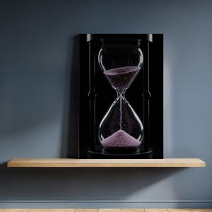 Op de afbeelding: Een zwarte zandloper met heldere glazen bollen en een zwart frame. De zandloper bevat paars zand dat van de bovenste bol naar de onderste bol stroomt. De zandloper wordt tentoongesteld op een houten plank tegen een donkerblauwe muur.