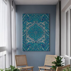 May include: A large, rectangular canvas artwork with a detailed, symmetrical pattern in turquoise and white. The design features floral and geometric elements. The artwork is mounted on a blue wall, above two wooden chairs with woven seats.