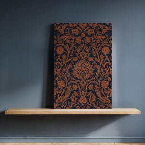 May include: A rectangular canvas featuring a detailed damask pattern in shades of navy blue and copper. The floral design is ornate and symmetrical. The canvas is displayed on a light-colored wooden shelf against a dark blue wall.