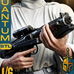 May include: A black and gray 1/6th scale blaster rifle with a scope, held by a person wearing a white outfit. The image includes the text "QUANTUM STL" and a logo with a sword and helmet.