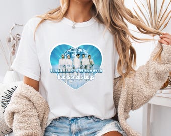 May include: White t-shirt featuring a heart-shaped graphic with the text "Into the Millennium Backstreet Boys." The graphic includes a photo of the band members in white outfits against a blue background.