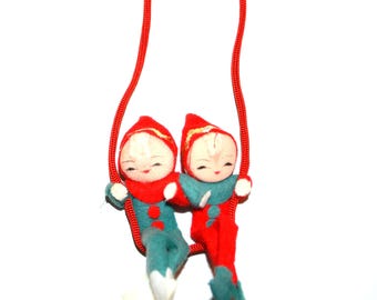 Pixie Elves uit de jaren 50 op sleeplift of schommel rood