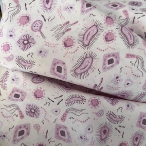 May include: A white fabric featuring a repeating pattern of various microorganisms in shades of purple and pink. The design includes illustrations of bacteria, viruses, and cells with flagella, cilia, and geometric shapes scattered across the surface.