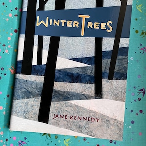May include: A book titled Winter Trees by Jane Kennedy featuring a cover illustration of black tree silhouettes against a blue and white snowy landscape with textured patterns. The title is written in yellow and white text on a blue banner.