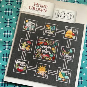 Pode incluir: Um design Home Grown Art-to-Heart com um fundo preto, apresentando citações inspiradoras e ilustrações florais. O design inclui frases como "Love Lives Here", "Keep Your Promises" e "Family is Forever".